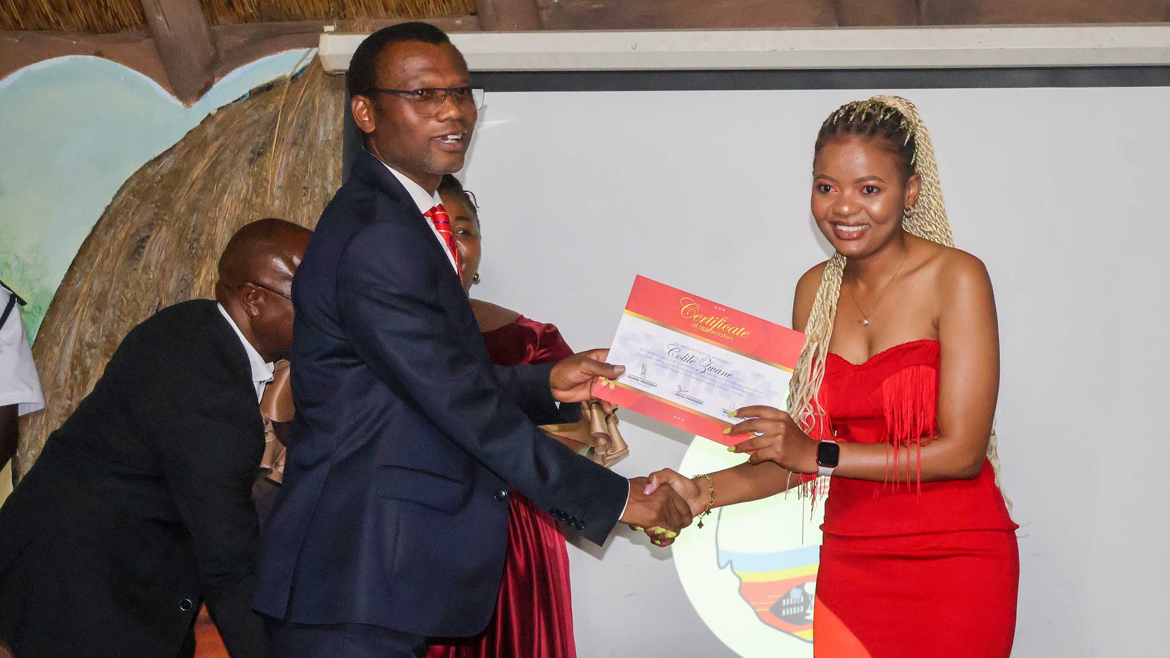 Colile Zwane receives her certificate of honour from Minister for Housing and Urban Development; Appolo Maphalala after her logo design was selected as the face of the 2026 SAIMSA Games. (Pic: Nimrod Hlophe)